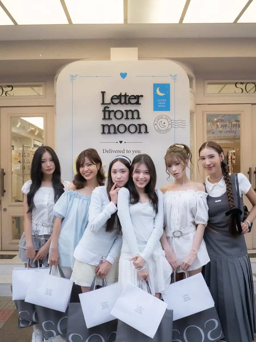 SOS 시암스퀘어점 입구의 Letter from moon 조형물 앞에 모여 선 태국 인플루언서들 — 저마다 SOS 쇼핑백을 들고 있습니다